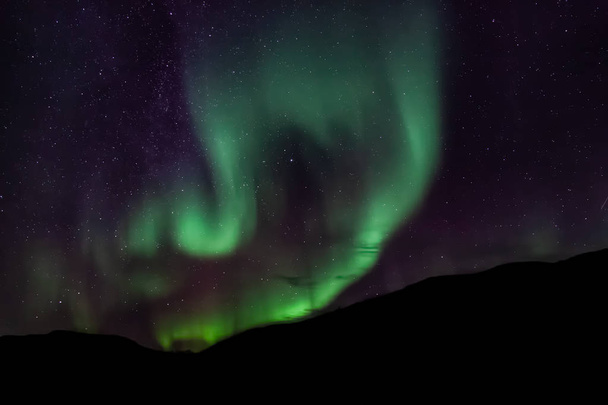 Şaşırtıcı Aurora Borealis Kuzey Norveç (Kvaloya), arka planda dağlar - Fotoğraf, Görsel