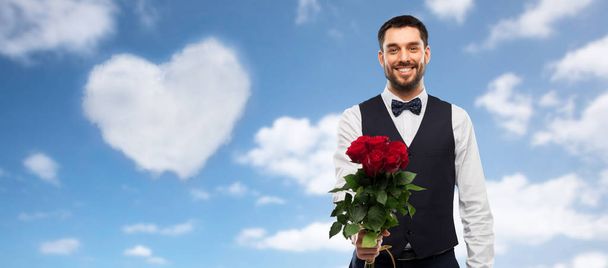 ευτυχισμένος άνθρωπος με μπουκέτο από κόκκινα τριαντάφυλλα - Φωτογραφία, εικόνα