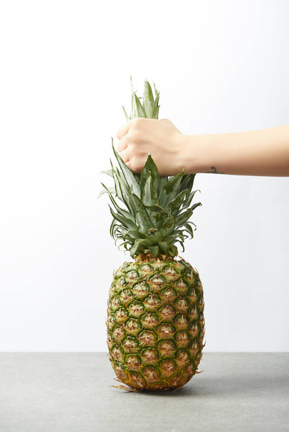 cropped view of female hand holding tasty pineapple isolated on white - Foto, Imagen
