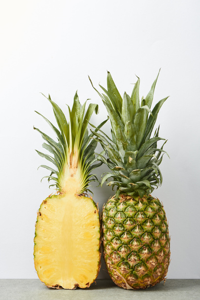 whole and half of ripe pineapples isolated on white  - Valokuva, kuva