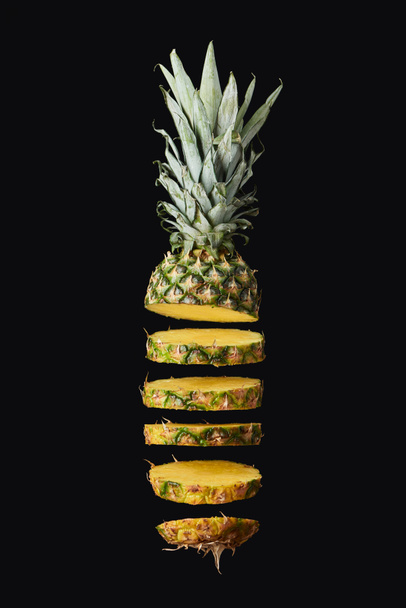 sliced, tasty and sweet pineapple isolated on black  - Photo, Image