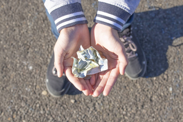 Un enfant tient dans ses mains des pièces et des billets en euros. Image d'argent de poche. Famille pauvre à faible revenu, concept de pauvreté, mendicité
 - Photo, image