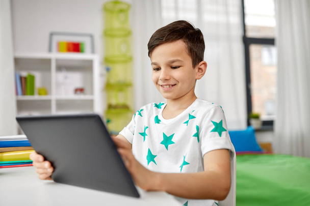 student boy with tablet pc and notebook at home - Valokuva, kuva