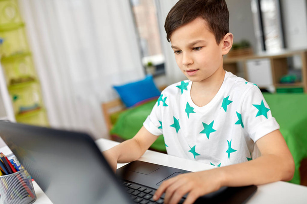 student boy typing on laptop computer at home - Fotoğraf, Görsel
