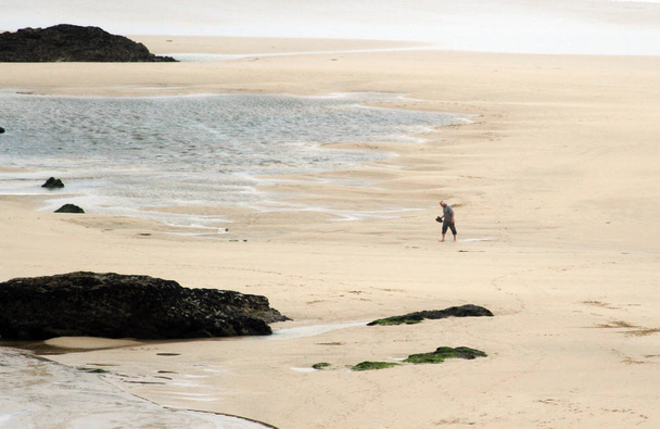 Silhouette di un uomo che cammina nell'immensa spiaggia di Newquay, meta ambita dai surfisti. Newquay, Cornovaglia, Regno Unito
 - Foto, immagini