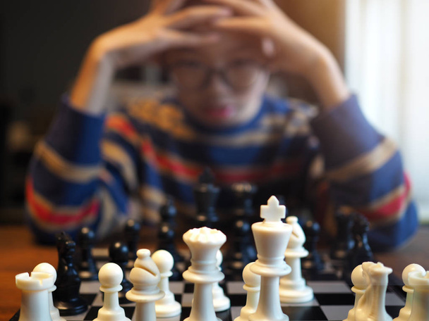 Blured obrázek asijské chlapce hrát šachy s vysokou koncentrací - Fotografie, Obrázek