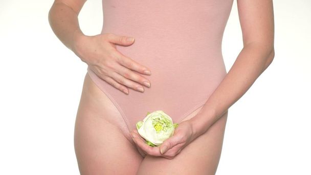Woman holding a flower on the background of underwear, the concept of female health and body care - Фото, зображення