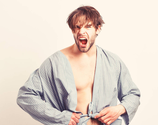 Sexy macho with angry face stands in bathrobe. Morning concept. - Photo, Image