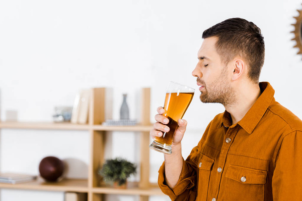 όμορφος άνδρας στο μοντέρνο σαλόνι πίνοντας μπύρα - Φωτογραφία, εικόνα
