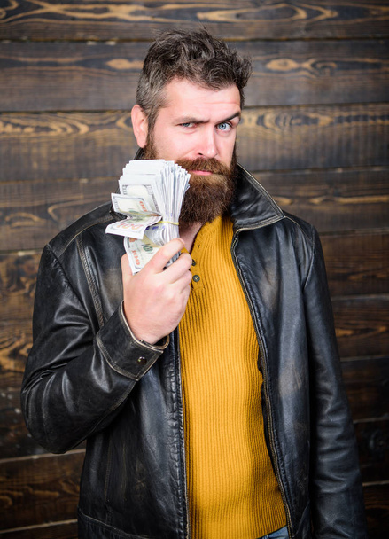 Brutal man has cash money. Richness and wellbeing. Man brutal bearded hipster wear leather jacket and hold cash money. Mafia business. Illegal profit and black cash. Guy mafia dealer with cash profit - Zdjęcie, obraz