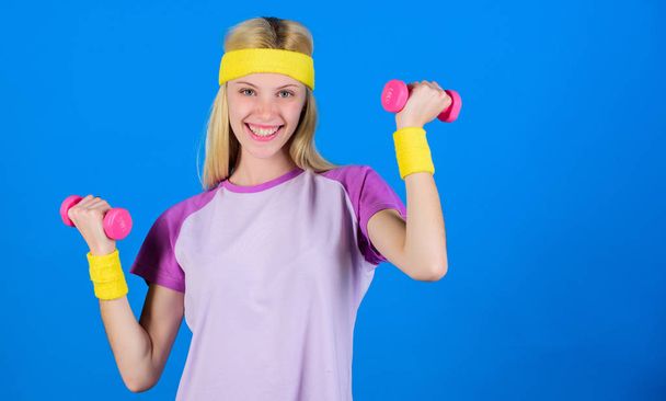 Girl exercising with dumbbell. Workout with dumbbell. Beginner dumbbell exercises. Ultimate upper body workout for women. Fitness instructor hold little dumbbell blue background. Fitness concept - Photo, Image