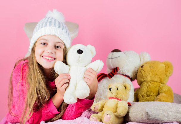 Kid little girl play with soft toy teddy bear on pink background. Bears toys collection. Child small girl playful hold teddy bear plush toy. Teddy bears help children handle emotions and limit stress - 写真・画像