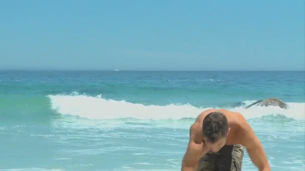Man coming out of the sea to pick up a soccer ball - Footage, Video