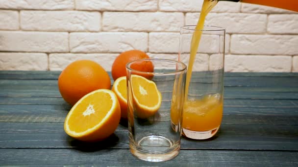El jugo de naranja se vierte en vasos sobre una mesa de madera. Comida saludable, dieta. Concepto de desayuno
 - Imágenes, Vídeo