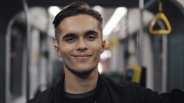 Handsome man looking at the camera in the tram and smiling, steadycam shot. Close-up. - Video, Çekim