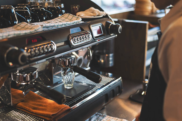 Nahaufnahme-Kaffeemaschine mit Softfokus und Überlicht im Hintergrund - Foto, Bild