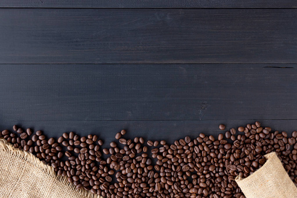 coffee beans in burlap sack on old wooden background. top view - Photo, Image
