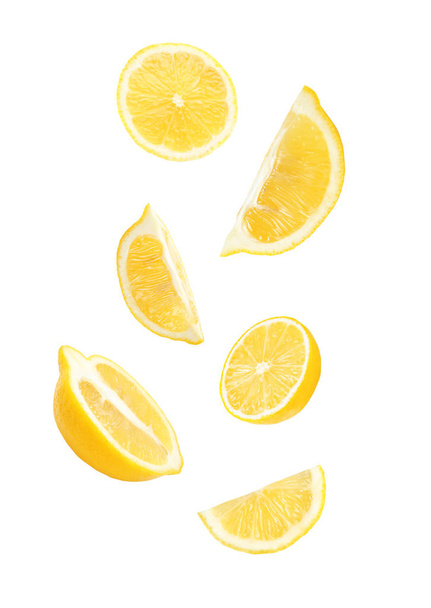 Cut fresh lemons falling against white background - Foto, imagen