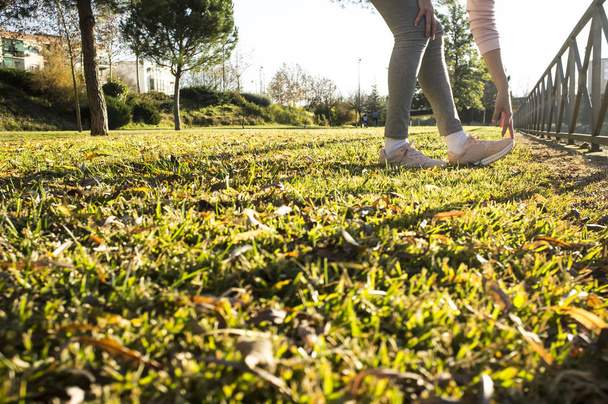 Vrouw doet stretching oefeningen op stadspark in herfst seizoen. Get in Shape in Your 30s concept - Foto, afbeelding