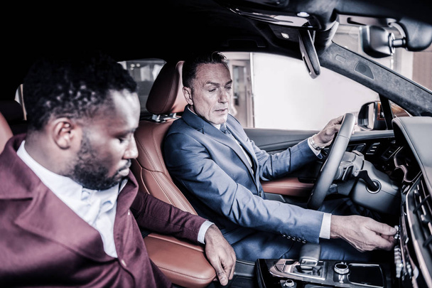 Два бизнес-партнера сидят в машине с кожаным салоном
 - Фото, изображение