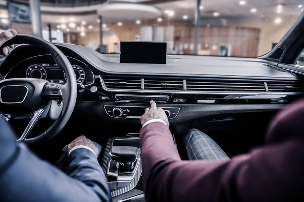 Два стильных бизнесмена сидят в роскошном автомобиле с кожаным интерьером
 - Фото, изображение