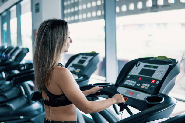 Young fit woman doing running exercise in gym - Photo, Image