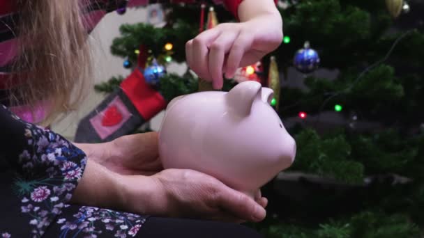Vrouw houden piggy bank waar dochter ter munten - Video
