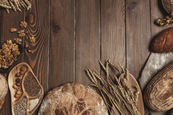Whole grain multigrain bread, whole and sliced, contains seeds isolated on black - Valokuva, kuva
