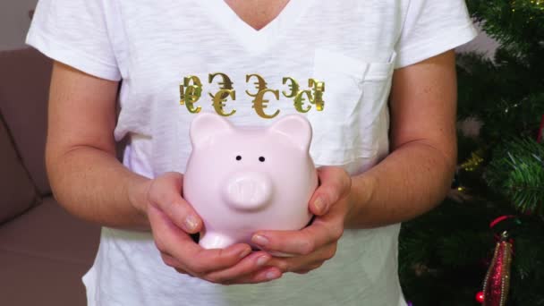 Nő tartás rózsaszín piggy bank euró jel fogalma - Felvétel, videó