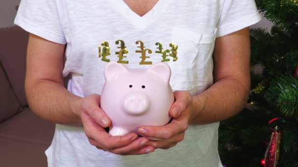 Mulher mantendo o banco piggy rosa com conceito de sinal de libra britânica
 - Filmagem, Vídeo