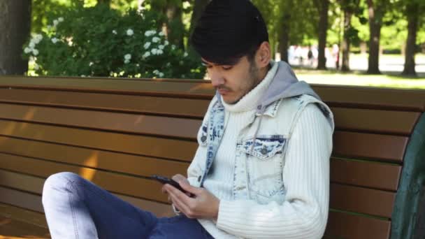 Man student surfing in internet using smartphone - Πλάνα, βίντεο