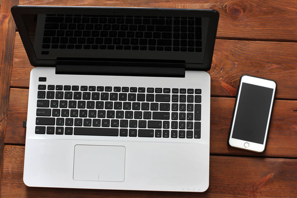 Laptop and phone on wooden background - Fotó, kép