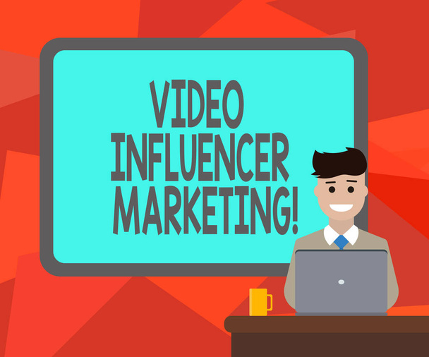 Word writing text Video Influencer Marketing. Business concept for Sponsored content by influencer to promote brand Blank Bordered Board behind Man Sitting Smiling with Laptop Mug on Desk. - Photo, Image