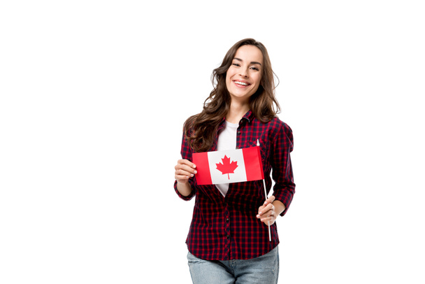 красивая улыбающаяся женщина, держащая канадский флаг и смотрящая на камеру, изолированную на белом
 - Фото, изображение