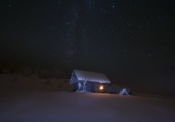 wooden house in winter forest - Foto, imagen