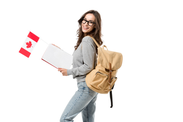 estudante feliz do sexo feminino com mochila segurando bandeira canadense e notebook isolado no branco
 - Foto, Imagem