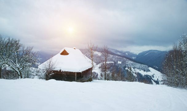 Fantastic winter landscape with wooden house in snowy mountains. Christmas holiday concept. Carpathians mountain, Ukraine, Europe - Photo, Image