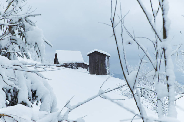 Fantastic winter landscape with wooden house in snowy mountains. Christmas holiday concept. Carpathians mountain, Ukraine, Europe - Fotó, kép