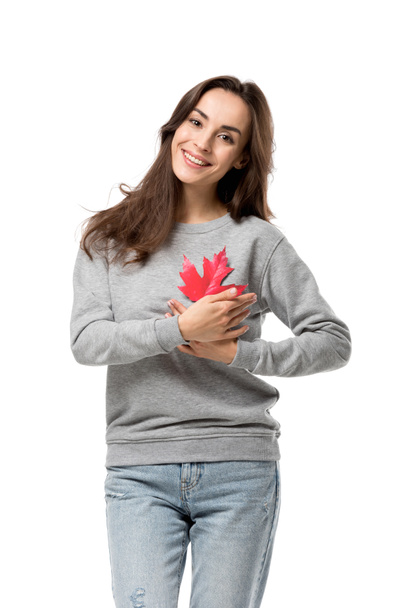 beautiful smiling woman in casual clothes holding maple leaf isolated on white - Photo, Image