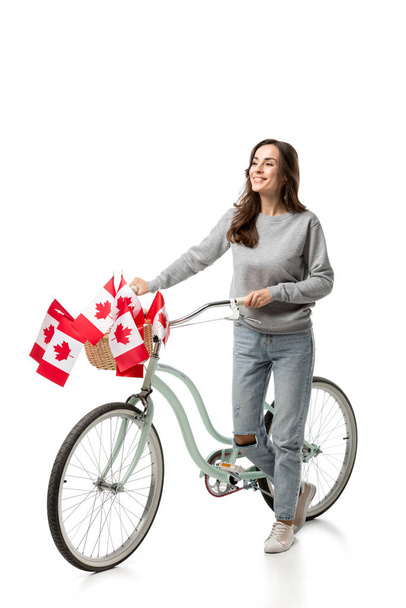 красивая женщина с винтажным велосипедом и канадскими флагами изолированы на белом
 - Фото, изображение
