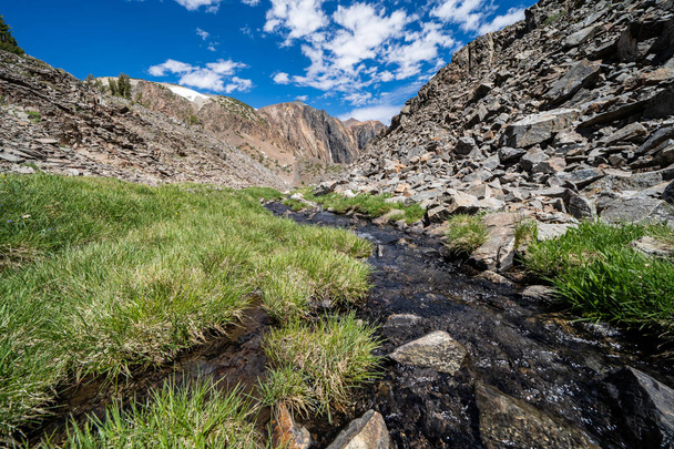 Grama verde exuberante, um riacho fluente e grandes rochas ao longo da trilha de caminhadas na 20 Lagos Basin - Eastern Sierra Nevada California
 - Foto, Imagem