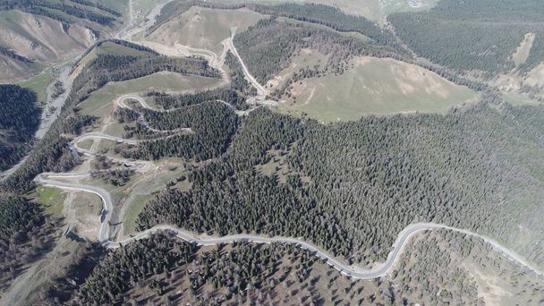 Vista aérea de un sinuoso camino de montaña con 18 curvas alrededor del Tian Shan, también conocido como Tengri Tagh, montaña en la ciudad de Hami, región autónoma de Xinjiang Uyghur al noroeste de China, 13 de mayo de 2018
. - Foto, imagen