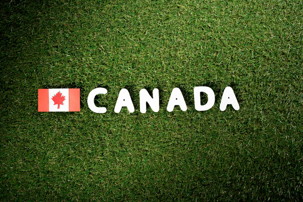felülnézet szó "Kanada" kanadai zászló a zöld fű háttér - Fotó, kép