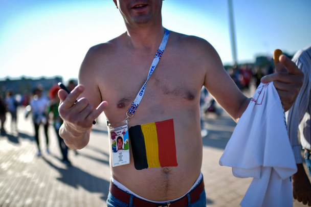 A Belgian fan is painted with a national flag as he and others gather outside the Kaliningrad Stadium before the Group G match between England and Belgium during the 2018 FIFA World Cup in Kaliningrad, Russia, 28 June 2018. - Foto, afbeelding