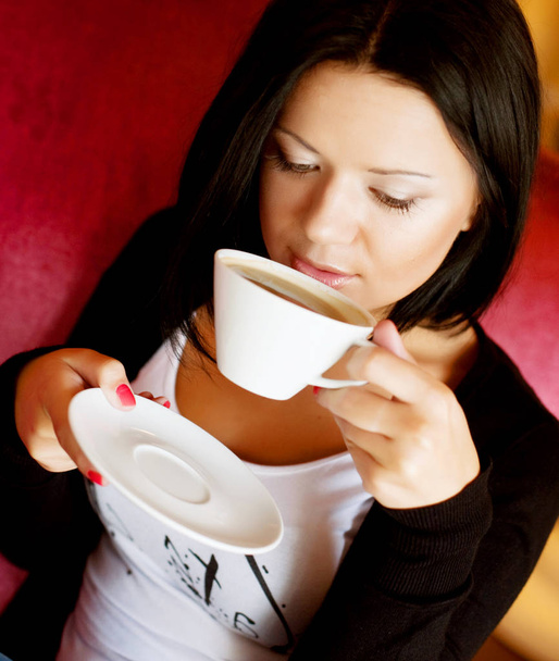 young woman sitting in a cafe drinking coffee - Foto, imagen