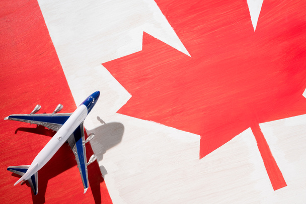 plane model with canadian flag on background, immigration concept - 写真・画像