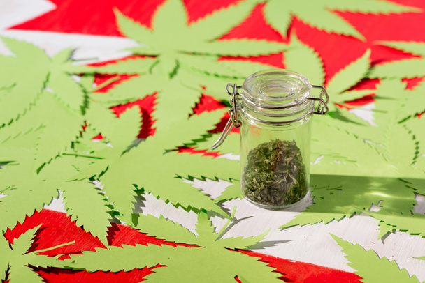 hojas de papel de marihuana en bandera canadiense con cannabis en frasco de vidrio, concepto de legalización de la marihuana
 - Foto, Imagen