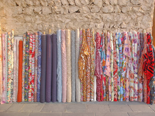 Coloridos rollos de tela árabe en la calle
 - Foto, Imagen