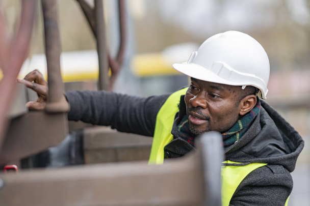 Mécanicien afro-américain portant un équipement de sécurité (casque et veste) contrôle train d'engrenages
 - Photo, image