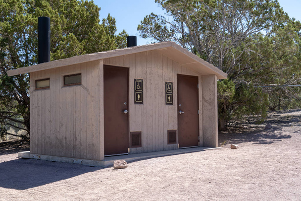 rustikale Grubentoliet Badezimmer im Freien mit zwei Ständen an einem sonnigen Tag in einem Park - Foto, Bild